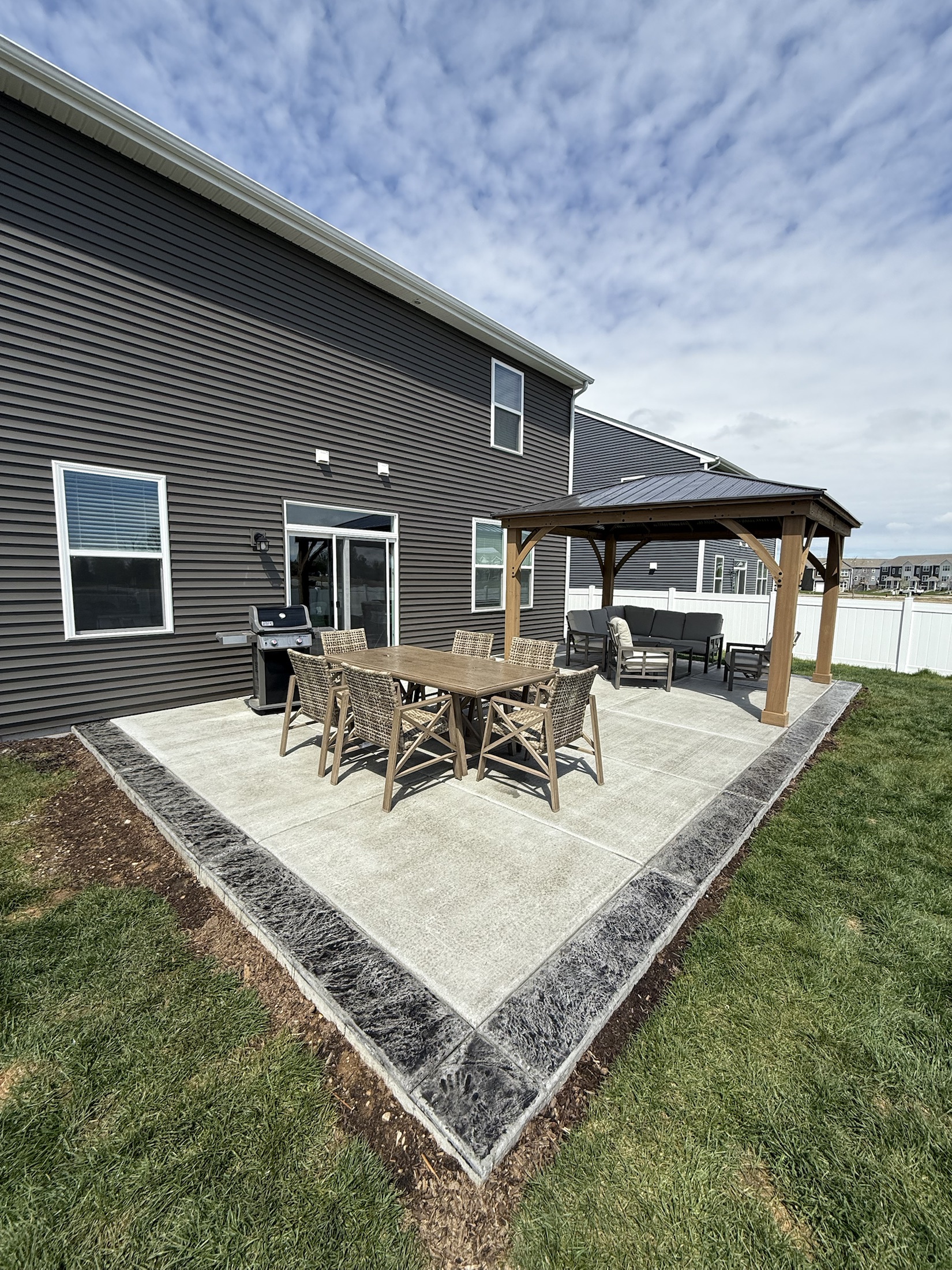 Backyard patio seating area by PFS Concrete & Asphalt